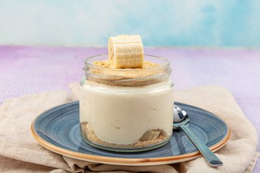 Manolya Tatlısı. Muz manolyası. Ahşap zemin üzerinde cam bardakta manolya tatlısı..