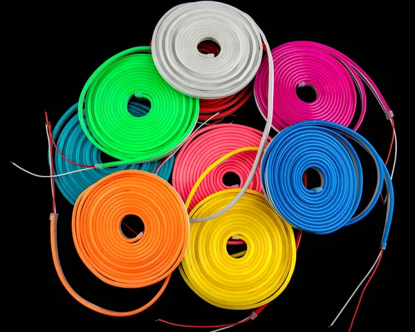 Neon flexible strip light. Flexible led tape neon flex in different colors on black background.