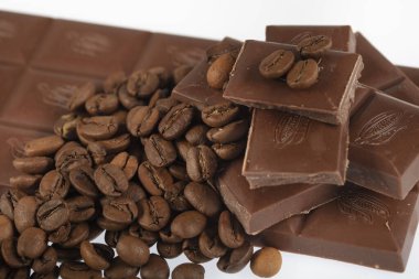 Çikolata-Kahve arka planı: Kırık barın parçalanmış parçaları koyu acı veya sütlü çikolata ve gölgesiz beyaz arka planda izole edilmiş birçok kahve çekirdeği