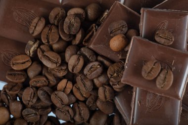 Çikolata-Kahve arka planı: Kırık barın parçalanmış parçaları koyu acı veya sütlü çikolata ve gölgesiz beyaz arka planda izole edilmiş birçok kahve çekirdeği