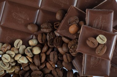 Çikolata-Kahve arka planı: Kırık barın parçalanmış parçaları koyu acı veya sütlü çikolata ve gölgesiz beyaz arka planda izole edilmiş birçok kahve çekirdeği