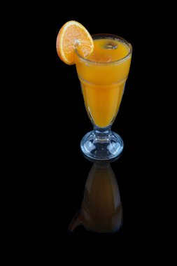 Taze sıkılmış portakal suyu. Taze portakal suyu ve siyah arka planda taze meyve portakalları..
