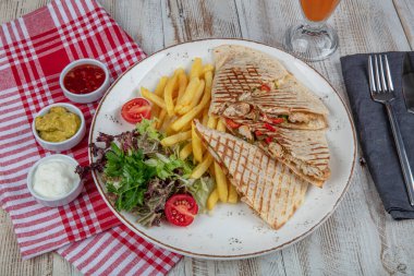 Kızarmış bufalo tavuklu sandviç dürümü, romaine marul, bleu peynir ve patates kızartması. Lavaşlı tavuklu tost..