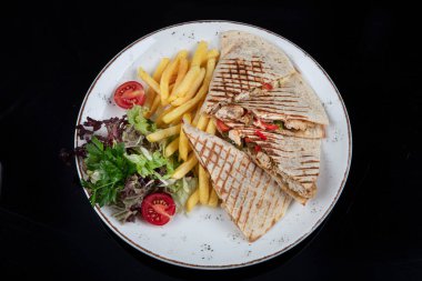 Kızarmış bufalo tavuklu sandviç dürümü, romaine marul, bleu peynir ve patates kızartması. Lavaşlı tavuklu tost..