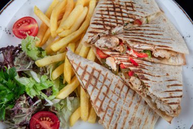 Kızarmış bufalo tavuklu sandviç dürümü, romaine marul, bleu peynir ve patates kızartması. Lavaşlı tavuklu tost..