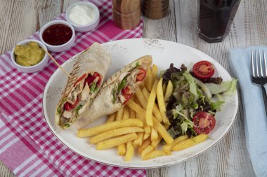Sağlıklı yiyecekler. Sebzeli tavuk dürümü. Köy arka planında taze salata soslu barbekü tavuğu..