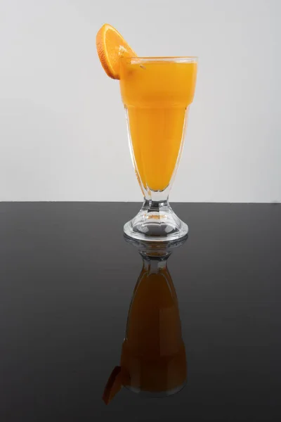 Freshly squeezed orange juice. Fresh orange juice and fresh fruit oranges on a black background.