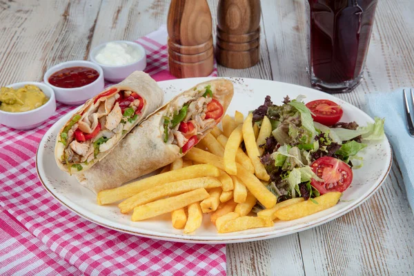 Healthy food. Delicious chicken wrap with vegetables. BBQ chicken with fresh salad tortilla wraps on rustic background.