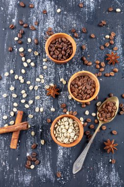 Koyu renkli arka planda üç farklı kahve çekirdeğinin üst görünümü.