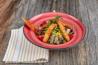 Yunan salatası ve ahşap masa arkasında kızarmış tavuk manzarası. Uzayı kopyala Sağlıklı yemek..