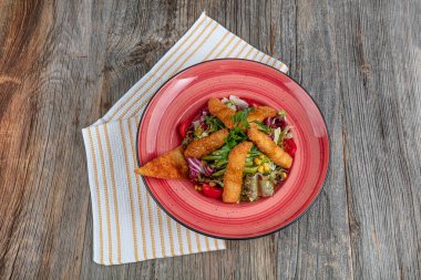 Yunan salatası ve ahşap masa arkasında kızarmış tavuk manzarası. Uzayı kopyala Sağlıklı yemek..