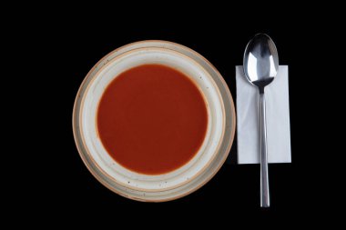 Bir tabak gazpacho - geleneksel İspanyol domates çorbası. Peçete, kaşık, domates, maydanoz, siyah zemin üzerinde beyaz bir kasede domates çorbası..