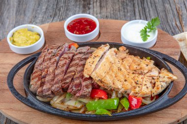 Combo Fajita; Meksika bifteği ve demir tavada fajita, dolma biberli ve soğanlı sıcak renkli açık renkli.