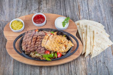 Combo Fajita; Meksika bifteği ve demir tavada fajita, dolma biberli ve soğanlı sıcak renkli açık renkli.