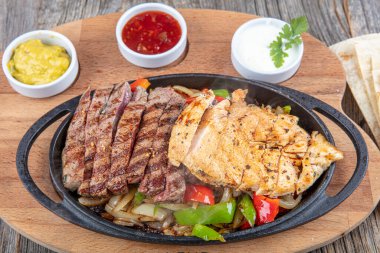 Combo Fajita; Meksika bifteği ve demir tavada fajita, dolma biberli ve soğanlı sıcak renkli açık renkli.