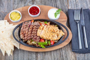 Combo Fajita; Meksika bifteği ve demir tavada fajita, dolma biberli ve soğanlı sıcak renkli açık renkli.