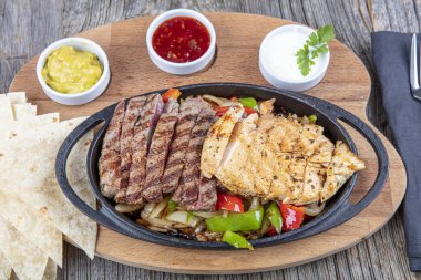 Combo Fajita; Meksika bifteği ve demir tavada fajita, dolma biberli ve soğanlı sıcak renkli açık renkli.