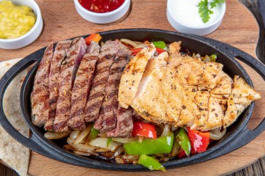 Combo Fajita; Meksika bifteği ve demir tavada fajita, dolma biberli ve soğanlı sıcak renkli açık renkli.