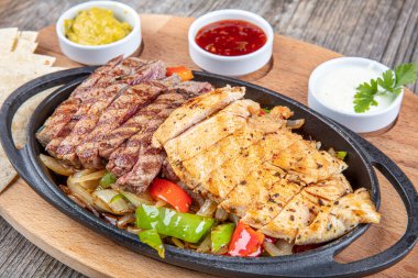 Combo Fajita; Meksika bifteği ve demir tavada fajita, dolma biberli ve soğanlı sıcak renkli açık renkli.