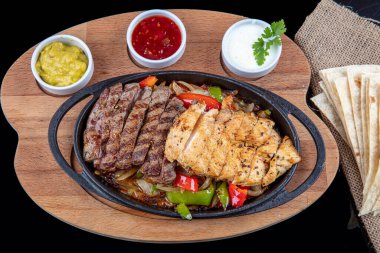Combo Fajita; Meksika bifteği ve demir tavada fajita, dolma biberli ve soğanlı sıcak renkli açık renkli.