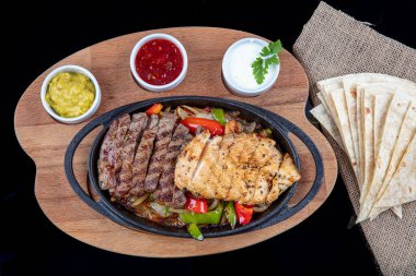 Combo Fajita; Meksika bifteği ve demir tavada fajita, dolma biberli ve soğanlı sıcak renkli açık renkli.