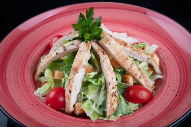 Sağlıklı ızgara tavuklu Sezar salatası ve kızarmış ekmek. Tahta masada taze, sağlıklı sezar salatası pişiyor. Üst görünüm