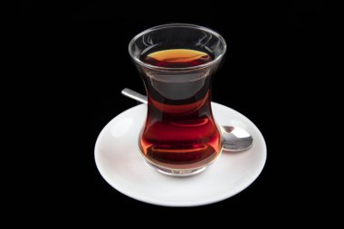 Siyah arka planda geleneksel bardakta servis edilen Türk çayı. Türk geleneksel sıcak içeceği.