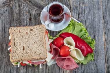 Salamlı taze sandviç, domates, marul, çedar peyniri ve Türk çayı..