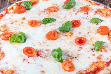 Margarita, mozzarella, peynir ve fesleğen yapraklı İtalyan pizzası..