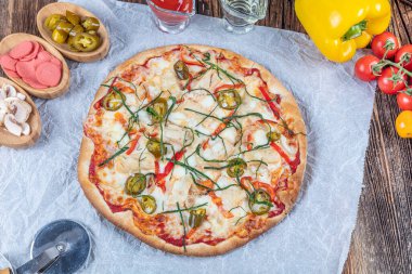 İtalyan Lezzetli Sıcak Karışık Fırında Tavuk Pizzası Eritilmiş Peynir, acılı biber, dilimlenmiş beyaz soğan, mantar, ahşap masa sade arka planda.