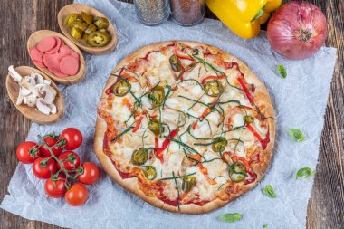 İtalyan Lezzetli Sıcak Karışık Fırında Tavuk Pizzası Eritilmiş Peynir, acılı biber, dilimlenmiş beyaz soğan, mantar, ahşap masa sade arka planda.