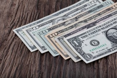 100 banknot halinde Amerikan doları. Ahşap arka planda çok para var..
