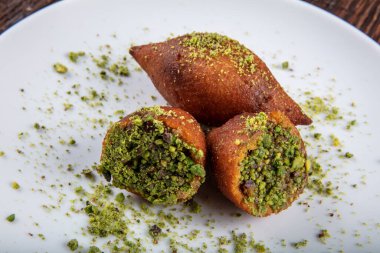 Kibbe doğulu restoran bifteği, kuzu eti, keçi eti ya da deve eti doldurulmuş bulgur kofta baharatlı köfte kızarmış köfte, yeşil salata yemeği, ahşap masa arkasında..