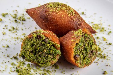Kibbe doğulu restoran bifteği, kuzu eti, keçi eti ya da deve eti doldurulmuş bulgur kofta baharatlı köfte kızarmış köfte, yeşil salata yemeği, ahşap masa arkasında..