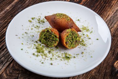 Kibbe doğulu restoran bifteği, kuzu eti, keçi eti ya da deve eti doldurulmuş bulgur kofta baharatlı köfte kızarmış köfte, yeşil salata yemeği, ahşap masa arkasında..