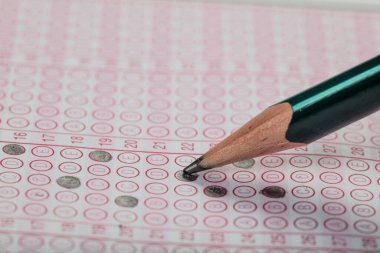 Sınavlara giren öğrencilerin elleri, optik test formunda kalem tutarak sınav kağıtları hazırlıyor ve sınıfta sınav kağıtları hazırlıyor. Eğitim Değerlendirme Kavramı. Yumuşak odak 