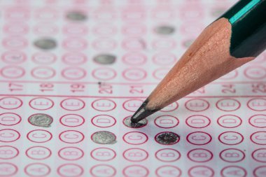 Sınavlara giren öğrencilerin elleri, optik test formunda kalem tutarak sınav kağıtları hazırlıyor ve sınıfta sınav kağıtları hazırlıyor. Eğitim Değerlendirme Kavramı. Yumuşak odak 