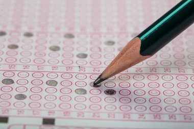 Sınavlara giren öğrencilerin elleri, optik test formunda kalem tutarak sınav kağıtları hazırlıyor ve sınıfta sınav kağıtları hazırlıyor. Eğitim Değerlendirme Kavramı. Yumuşak odak 
