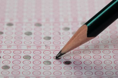 Sınavlara giren öğrencilerin elleri, optik test formunda kalem tutarak sınav kağıtları hazırlıyor ve sınıfta sınav kağıtları hazırlıyor. Eğitim Değerlendirme Kavramı. Yumuşak odak 