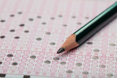 Sınavlara giren öğrencilerin elleri, optik test formunda kalem tutarak sınav kağıtları hazırlıyor ve sınıfta sınav kağıtları hazırlıyor. Eğitim Değerlendirme Kavramı. Yumuşak odak 