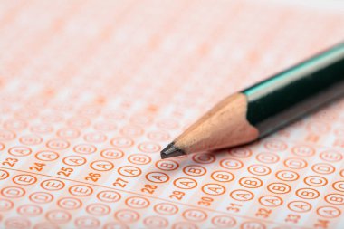 Sınavlara giren öğrencilerin elleri, optik test formunda kalem tutarak sınav kağıtları hazırlıyor ve sınıfta sınav kağıtları hazırlıyor. Eğitim Değerlendirme Kavramı. Yumuşak odak 