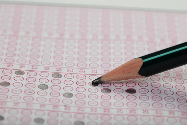 Sınavlara giren öğrencilerin elleri, optik test formunda kalem tutarak sınav kağıtları hazırlıyor ve sınıfta sınav kağıtları hazırlıyor. Eğitim Değerlendirme Kavramı. Yumuşak odak 