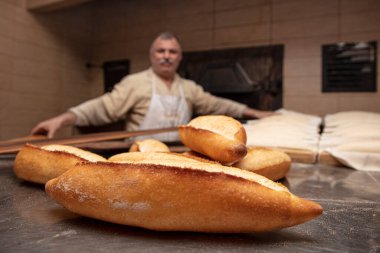 Fırın, ekmek yapma. Baker fırından taze ekmek alıyor. Türk ekmeği üretim süreci. 