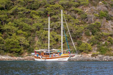 OLUDENIZ, TURKEY - 10 Ekim 2018: Türkiye 'nin Oludeniz kentindeki Kelebek Vadisi' nin masmavi kıyısındaki turizm gemisi 
