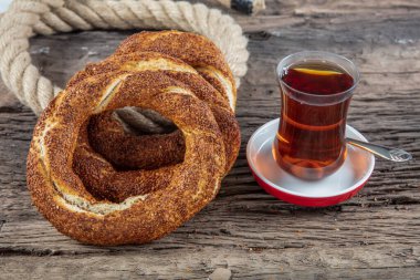 Kahvaltı için ahşap zemin üzerinde Türk Simit 'i. Türk simidi (simit, gevrek) ve çay. 