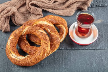 Kahvaltı için ahşap zemin üzerinde Türk Simit 'i. Türk simidi (simit, gevrek) ve çay. 