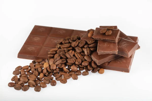 チョコレートコーヒーの背景 壊れたバーの散乱部分暗い苦味やミルキーチョコレートと影のない白い背景に隔離された多くの揚げコーヒー豆 — ストック写真