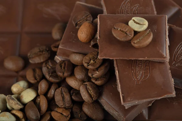 Çikolata-Kahve arka planı: Kırık barın parçalanmış parçaları koyu acı veya sütlü çikolata ve gölgesiz beyaz arka planda izole edilmiş birçok kahve çekirdeği