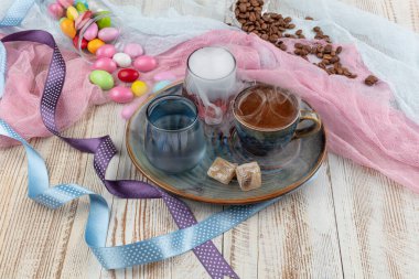 Porselen fincanda geleneksel Türk kahvesi, bir bardak su ve Türk lezzeti, kahve çekirdekli renkli badem şekerleri. Bir ziyafet (ziyafet) klasiği, Ramazan ziyafeti servis sunumu.