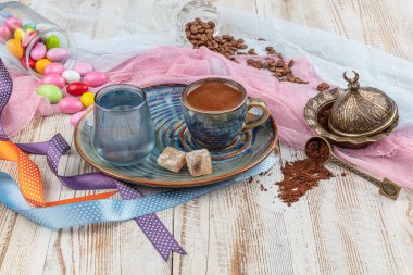 Porselen fincanda geleneksel Türk kahvesi, bir bardak su ve Türk lezzeti, kahve çekirdekli renkli badem şekerleri. Bir ziyafet (ziyafet) klasiği, Ramazan ziyafeti servis sunumu.